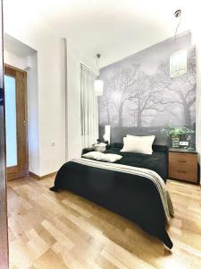 een slaapkamer met een zwart bed en een schilderij aan de muur bij Oasis city apARTment in Heraklion