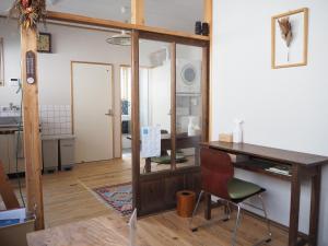 Habitación con escritorio de madera y silla. en Backpackers Hostel TSUBAMENOYADO, en Shizuoka