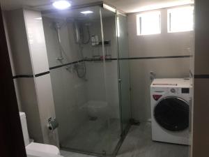 y baño con ducha y lavadora. en Central residence Rajagiriya-Entire House, en Sri Jayewardenepura Kotte
