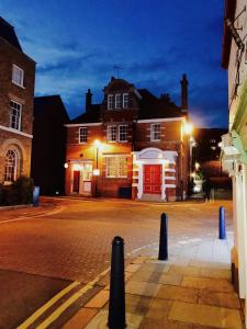 una calle por la noche con un edificio con una puerta roja en The Old Post Office Boutique Guesthouse, en Hythe