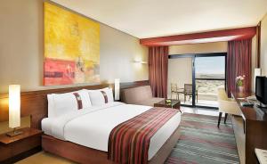 Habitación de hotel con cama grande y TV en Holiday Inn Resort Dead Sea, an IHG Hotel, en Sowayma