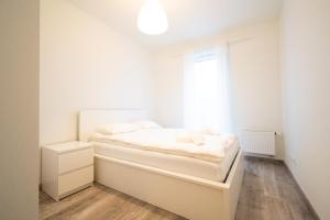 um quarto branco com uma cama e uma janela em Apartament Bravo em Lódź