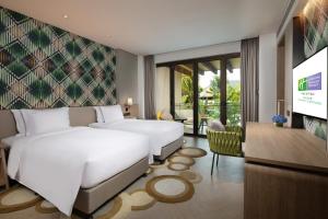 瓊海的住宿－瓊海官塘假日度假酒店，酒店客房设有两张床和一台平面电视。