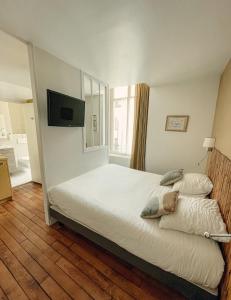 a bedroom with a bed and a flat screen tv at Garden Hotel Rennes Centre Gare in Rennes