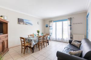 a living room with a table and chairs and a couch at Odessa in Lanton