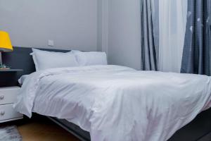 En eller flere senge i et værelse på Stay.Plus Oark Apartment Kisii