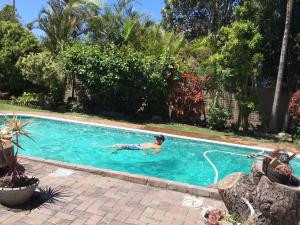 a man is swimming in a swimming pool at Log Inn in East London