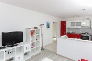 ein Wohnzimmer mit weißen Schränken und einem Flachbild-TV in der Unterkunft Apartments Posta in Saplunara