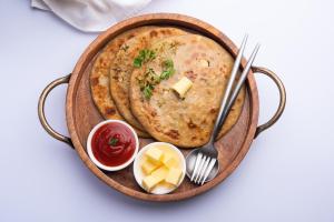 a bowl of hummus with a fork and a plate of food at Sukrangu Palace in Shirdi