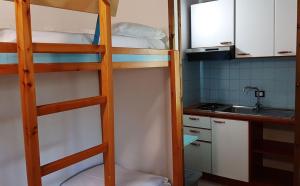 two bunk beds in a small kitchen with a sink at Le Dune Villaggio in Lido Di Fondi