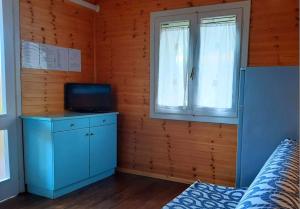 a bedroom with a blue cabinet and a window at Le Dune Villaggio in Lido Di Fondi