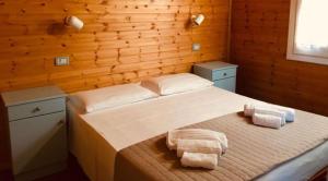 a bedroom with a bed with two towels on it at Le Dune Villaggio in Lido Di Fondi