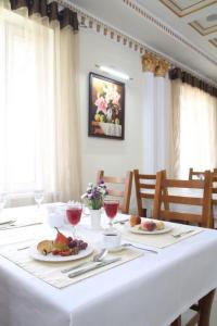 una mesa blanca con dos platos de comida. en Grand Nur Hotel, en Tashkent