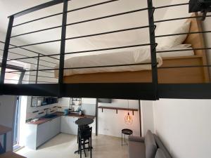 a loft bed in a room with a kitchen at Soppalco in Martina Franca