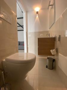 a white bathroom with a toilet and a sink at Soppalco in Martina Franca