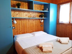 a bedroom with a bed with blue walls and shelves at Le Dune Villaggio in Lido Di Fondi
