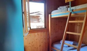 a room with bunk beds with a window and a ladder at Le Dune Villaggio in Lido Di Fondi