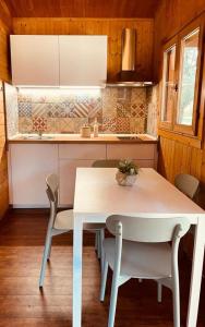 a kitchen with a white table and chairs in a room at Le Dune Villaggio in Lido Di Fondi