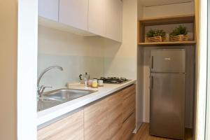 a kitchen with a sink and a refrigerator at Le Dune Villaggio in Lido Di Fondi