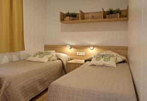 a small room with two beds and a table at Le Dune Villaggio in Lido Di Fondi
