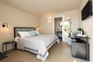 1 dormitorio con 1 cama blanca y TV en bed&breakfast Filomare, en Numana