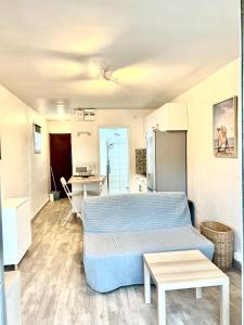 uma sala de estar com uma cama e uma cozinha em Chaleureux Studio - Calme et Lumineux - Point Zéro - Proximité Plage et Centre Ville em La Grande-Motte
