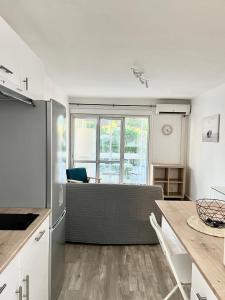 a kitchen with a table and a large window at Chaleureux Studio - Calme et Lumineux - Point Zéro - Proximité Plage et Centre Ville in La Grande Motte