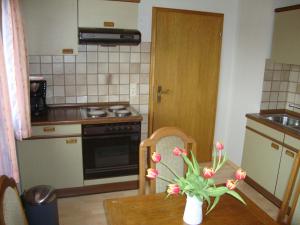 eine Küche mit einem Tisch und einer Blumenvase darauf in der Unterkunft Haus Reif in Dombühl