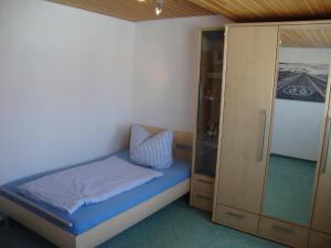 ein kleines Schlafzimmer mit einem Bett und einem Schrank in der Unterkunft Haus Reif in Dombühl