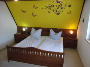1 dormitorio con 1 cama con mariposas en la pared en Haus Reif, en Dombühl