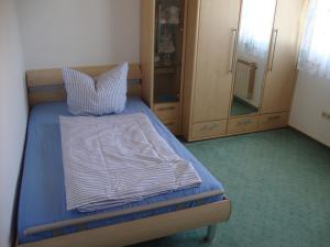 a bedroom with a bed with a pillow and a cabinet at Haus Reif in Dombühl