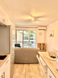 a kitchen with a table and a couch in a room at Chaleureux Studio - Calme et Lumineux - Point Zéro - Proximité Plage et Centre Ville in La Grande Motte