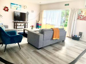 a living room with a couch and a tv at Rotorua City Center Holiday House in Rotorua