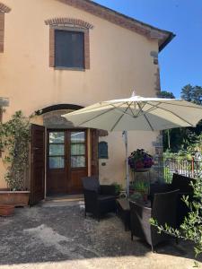 an umbrella and chairs in front of a house at Morelliana4Rooms in Scansano