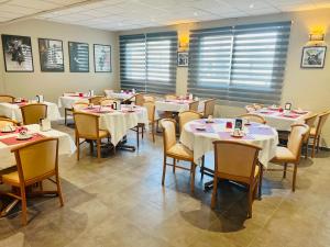 a dining room with tables and chairs with white table cloth at Resothel Group in Le Cannet