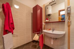 uma casa de banho com um lavatório e um armário vermelho em Residenza Al Parco em Bibione