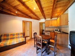 - une cuisine et une salle à manger avec une table et un lit dans l'établissement Apartament L'àtic, à Espot