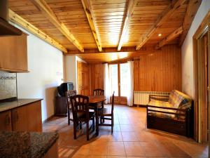 - une cuisine et une salle à manger avec une table et des chaises dans l'établissement Apartament L'àtic, à Espot