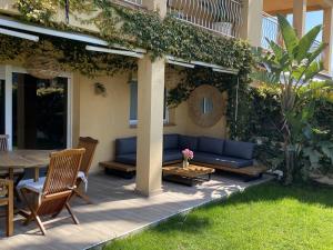 un patio con un sofá azul y una mesa en Rocamar Villa Private Pool & 5min to the Beach by Olala Homes, en Sant Pere de Ribes