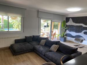 uma sala de estar com um sofá preto e uma mesa em Rocamar Villa Private Pool & 5min to the Beach by Olala Homes em Sant Pere de Ribes