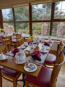 a dining room with a wooden table with chairs and a table at Glenn Eireann House in Cushendun +55 photos