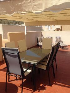 una mesa y sillas bajo una sombrilla en un techo en AZ02 Roof top terrace apartment, 2 bedrooms, 1 bathroom, very close to beach, en La Azohía
