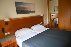 ein Schlafzimmer mit einem blauen Bett und einem Spiegel in der Unterkunft Hotel Doña Catalina in Marbella