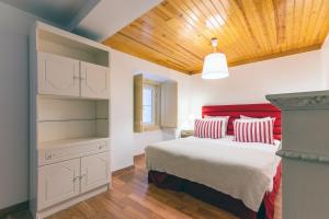 a bedroom with a bed with red and white pillows at Portas do Teatro Apartments 2 in Lisbon