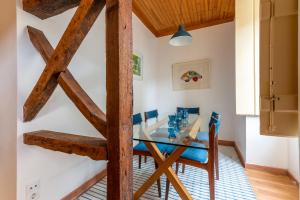 a dining room with a glass table and blue chairs at Portas do Teatro Apartments 2 in Lisbon