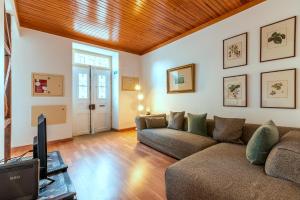 a living room with a couch and a tv at Portas do Teatro Apartments 2 in Lisbon