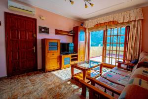 Solarium Agaete Valley Retreat 3-BR في أَغايتي: غرفة معيشة بها أريكة وتلفزيون