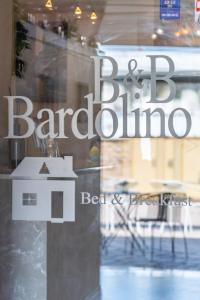 un riflesso di un cartello del barbiere in una finestra di Affittacamere Bardolino a Calmasino