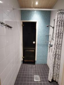 a bathroom with a walk in shower and a door at Lomasaaga 9 in Syöte