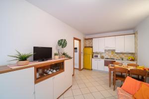 a kitchen and dining room with a tv on a counter at Residenza Le Altane in Bibione